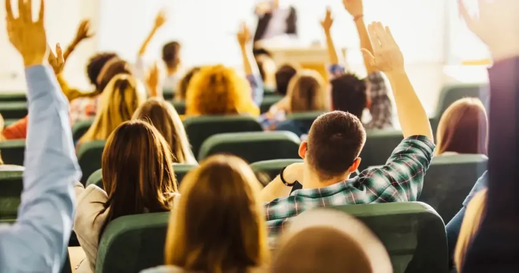 Study Abroad vs Studying in Your Home Country: students raising hands in a classroom
