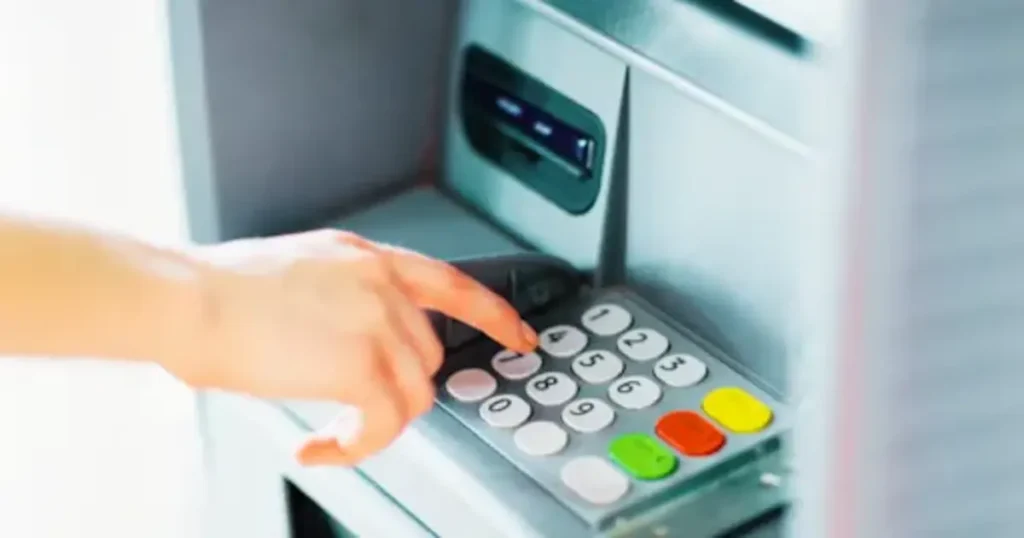 Person using ATM to manage money after opening a bank account in the UK