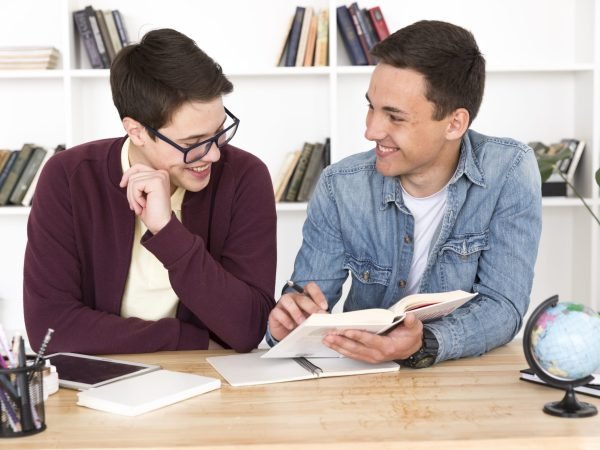 smiling-students-reading-book